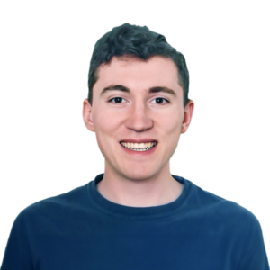 Headshot of a smiling man in blue shirt on a black background.